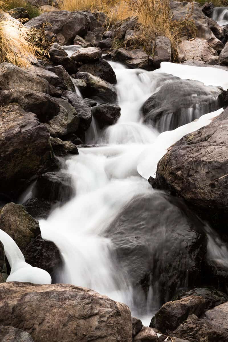Closeup shot of the water flowing through stones