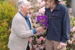 Glenda Rowlands and John Harvey share a moment in the Te Rangimarie garden